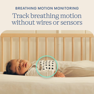 Baby lying in a crib with text about breathing motion monitoring without wires or sensors.