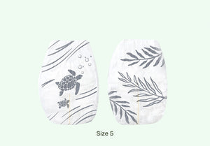 Pair of white socks with turtle and leaf patterns on a light green background